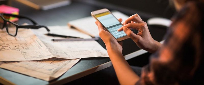 Businesswoman using smart phone-blue prints